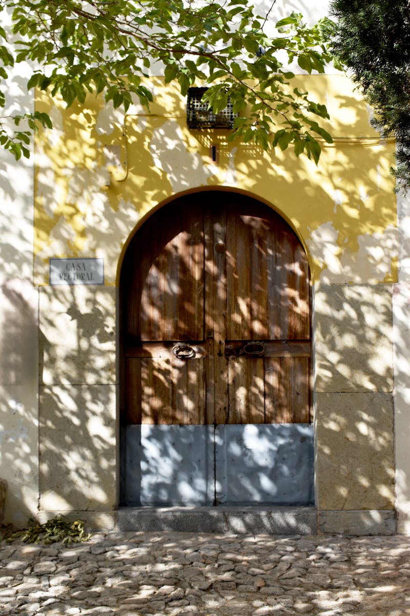 A door with a shadow on it in a courtyard